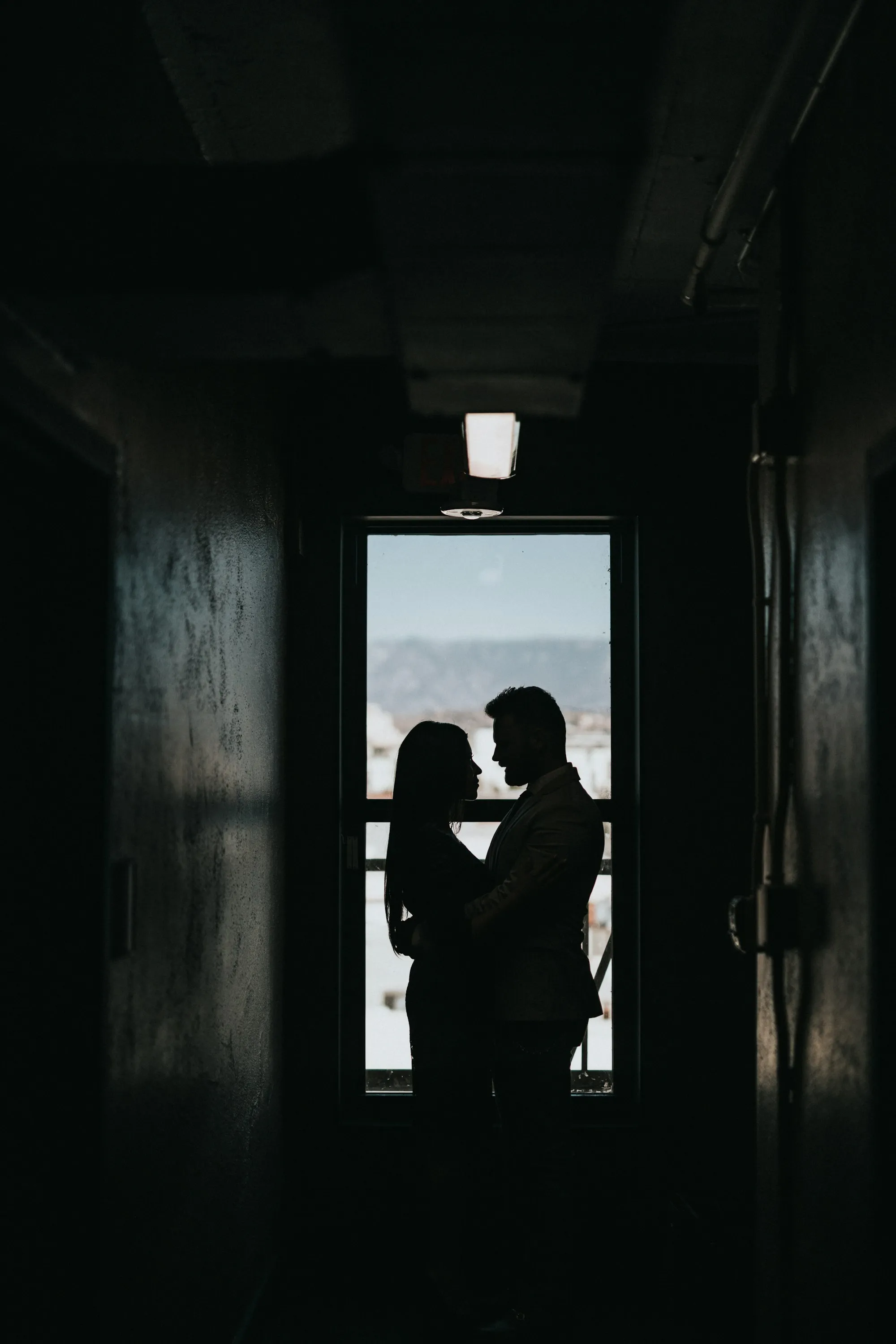 Two silhouettes facing each other by a window